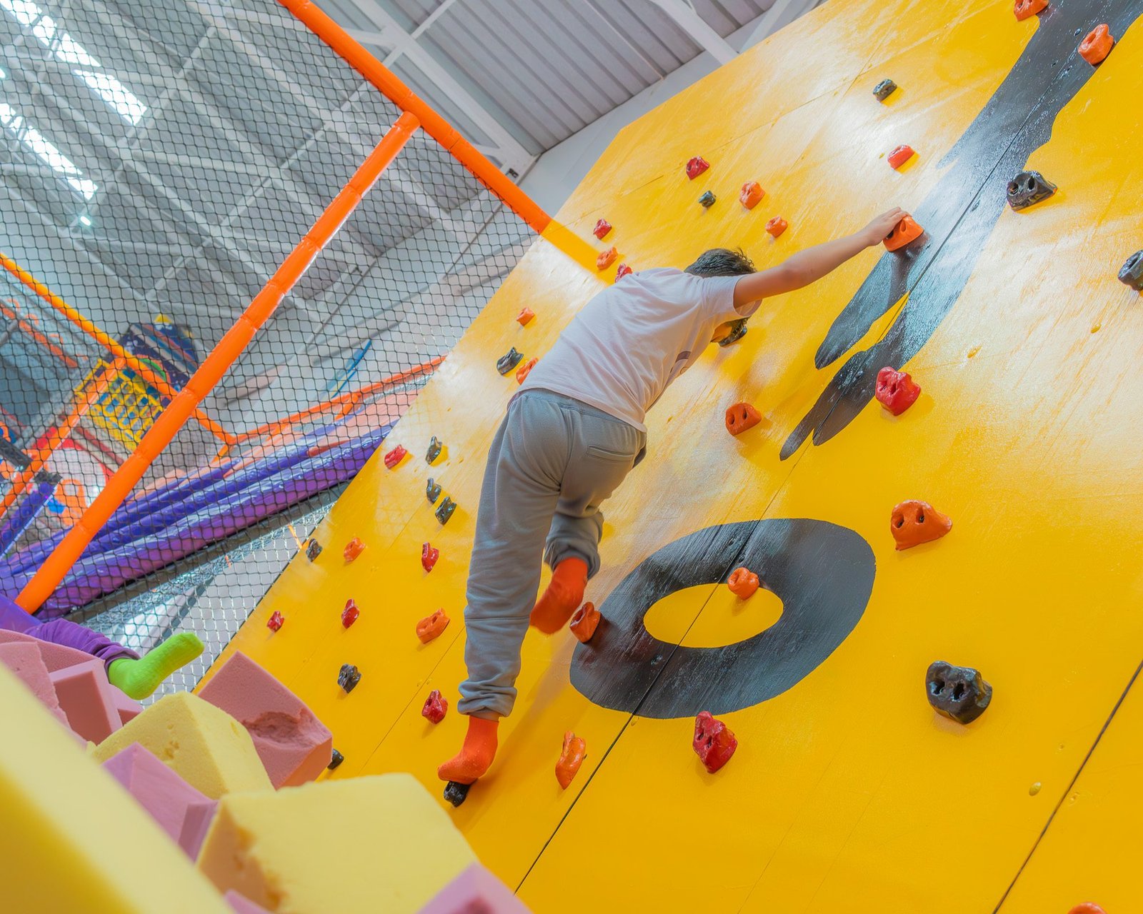 Niño escalando el muro de escalada